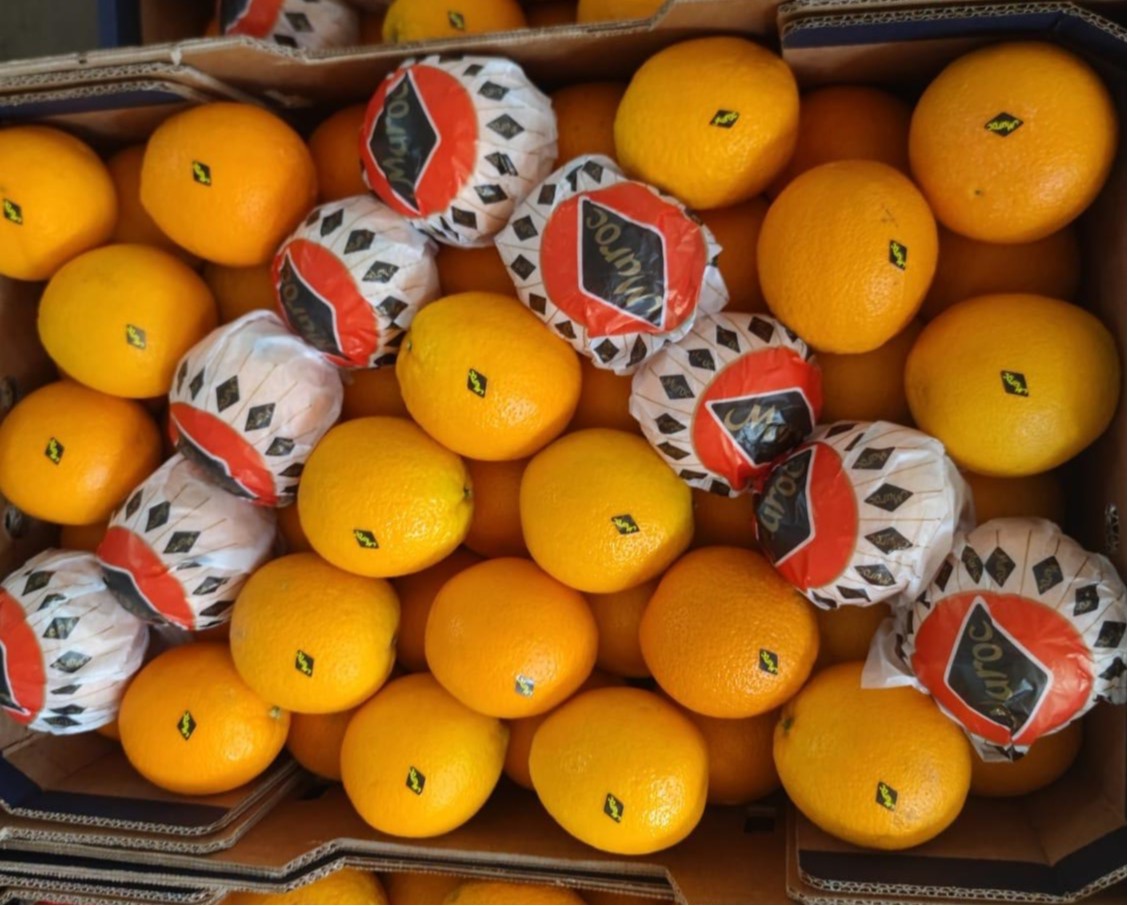 Citrus shipment inspection with wrapped and unwrapped oranges in export crates